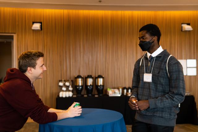 This is a candid photo of a mentor speaking with a protégé